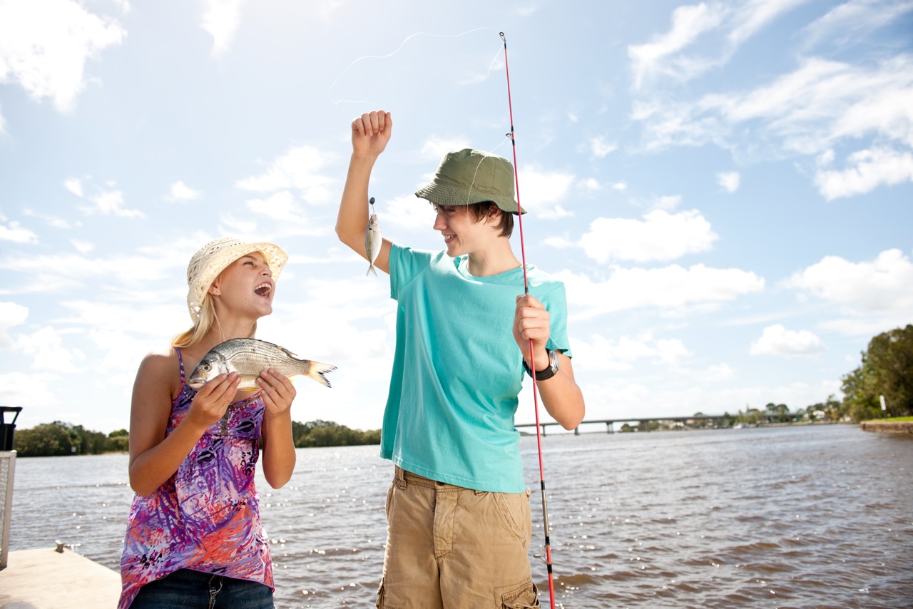 A brother happily showing his sister the fish